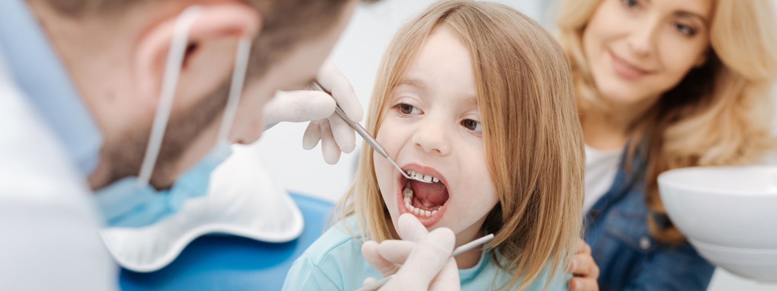 Small girls mouth being examine by the Dentist