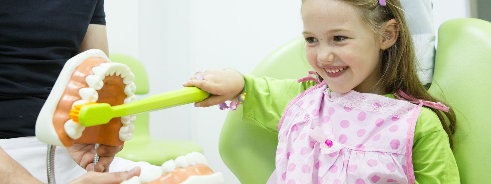 Small girl brushing a big Teeth Model