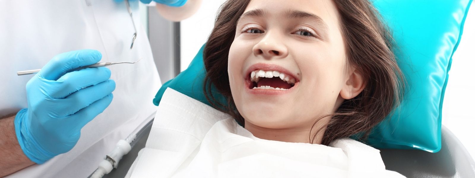 Small girl in a Dental chair smiling happy